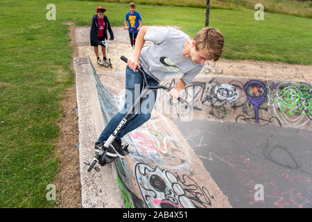 Einer der britischen Top roller Rider Josh Glas üben an der lokalen Skatepark, Stunts auf der ganzen Skatepark mit Menschen beobachten auf Stockfoto