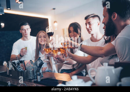 Freizeit- und Kommunikationskonzept. Gruppe von Glücklich lächelnde Freunde Drinks genießen und die Unterhaltung an der Bar oder pub Stockfoto