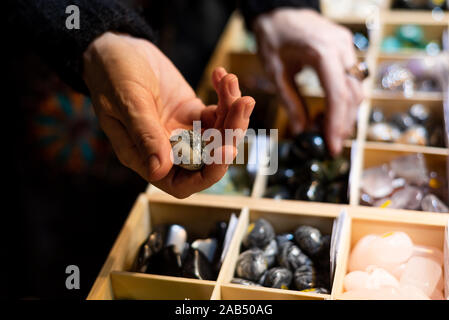 Nahaufnahme der Frau Hände herauf Edelsteine an Steinen Trade Show Display von den Regalen Stockfoto