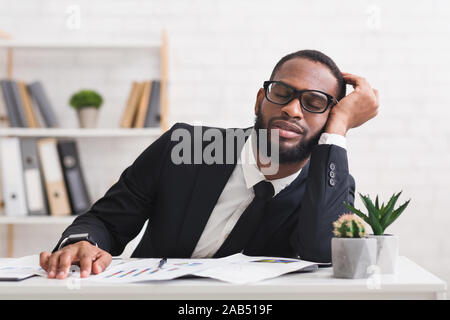 Müde schwarzer Geschäftsmann in Gläser nap in seinem Büro Stockfoto