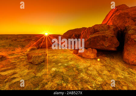 Lebendige orangen und roten Farben des Sonnenuntergangs Himmel über riesige Granitfelsen bei Karlu Karlu oder Devils Marbles in Northern Territory, Australien. Luftaufnahme Stockfoto