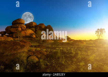 Vollmond im australischen Outback der Devils Marbles Felsformationen an der Dämmerung der Sonne Himmel. Granitfelsen von Karlu Karlu Devils Marbles Stockfoto