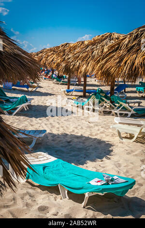 Reihe der Strand Unterstände und Stühle auf dem Sandstrand von Varadero, Kuba Stockfoto