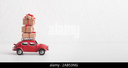 Rotes Auto Volkswagen Käfer mit Weihnachten Geschenkboxen auf Weiß Stockfoto