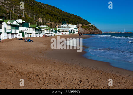 Platja de Les Casetes del Garraf, Garraf, Barcelona, Katalonien. Die markanten kleinen grünen und weißen Strand Häuser sind im Beach Village von Garra Stockfoto