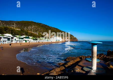 Platja de Les Casetes del Garraf, Garraf, Barcelona, Katalonien. Die markanten kleinen grünen und weißen Strand Häuser sind im Beach Village von Garra Stockfoto