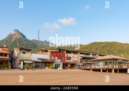 Ilha Grande, Brasilien. 24. Dezember, 2012. Angesichts der niedrigen Gebäuden neben Estacao Santorini Santorini (Ferry Terminal) und Cais Turistico da Vila do Santorini (touristische Pier von Santorini Dorf) auf sandigen Strand während der sonnigen Morgen gesehen, die Ilha Grande (Grosse Insel), die Gemeinde von Angra dos Reis, Bundesstaat Rio de Janeiro, Brasilien. Am 5. Juli 2019, Ilha Grande wurde von der UNESCO als Weltkulturerbe eingetragen. Stockfoto