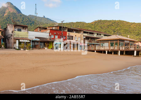 Ilha Grande, Brasilien. 24. Dezember, 2012. Angesichts der niedrigen Gebäuden neben Estacao Santorini Santorini (Ferry Terminal) und Cais Turistico da Vila do Santorini (touristische Pier von Santorini Dorf) auf sandigen Strand während der sonnigen Morgen gesehen, die Ilha Grande (Grosse Insel), die Gemeinde von Angra dos Reis, Bundesstaat Rio de Janeiro, Brasilien. Am 5. Juli 2019, Ilha Grande wurde von der UNESCO als Weltkulturerbe eingetragen. Stockfoto