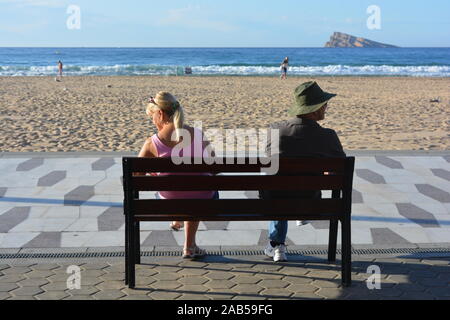 Paar im Freien, von hinten, auf einer Bank sitzen, Benidorm, Alicante, Spanien. Stockfoto