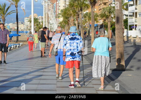 Gruppe von Senioren von hinten gesehen, Wandern am Strand Promenade, am frühen Morgen. Playa Levante, Benidorm, Alicante, Spanien Stockfoto