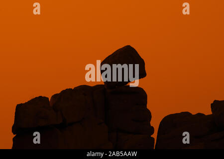 Seltsame Felsformationen Silhouette gegen Sonnenuntergang entlang der Côte de Granit rose/rosa Granit Küste, Côtes d'Armor, Bretagne, Frankreich Stockfoto