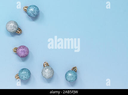 Glänzend bunten Christbaumkugeln Grenze auf einem blauen Hintergrund. Minimale flach Komposition mit Kopie Raum Stockfoto