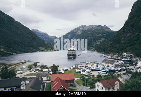 Geiranger, Norwegen - August 2017: Große Kreuzfahrtschiff der Fjord mit Stadt im Vordergrund günstig, Panoramaaussicht Stockfoto