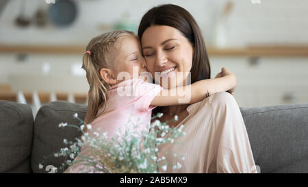 Kind Tochter Hug glückliche Mutter Blumen am Muttertag empfangen Stockfoto