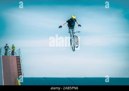 Junge unkenntlich Bmx Rider ein Fahrrad springen auf einem hohen Sprungbrett. Extreme Sport Stockfoto