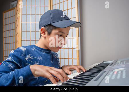 Junge, Alter 12, Lernen, Keyboard zu spielen Stockfoto