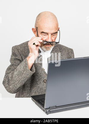 Ein alter Mann mit einem Laptop und Brille Stockfoto