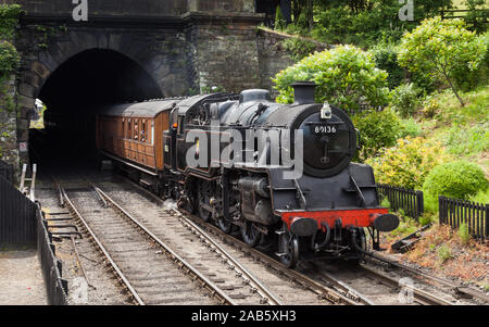 Eine Dampflok entsteht aus einem Tunnel auf der Annäherung zu Grosmont Station, auf der North Yorkshire Moors Railway. Stockfoto