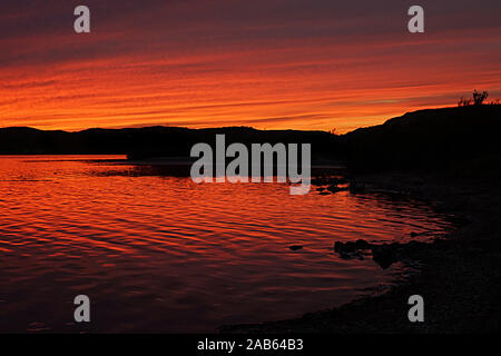 Schwarze silhouette Landschaft gegen einen farbenprächtigen Sonnenuntergang Himmel Stockfoto