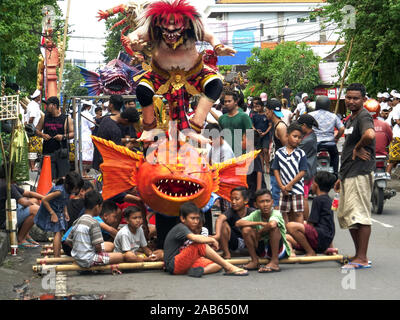 KUTA, Indonesien - März, 16, 2018: Kinder warten mit ihren ogoh ogoh Statue bei Kuta auf Bali Stockfoto