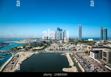 Abu Dhabi Skyline mit air show Farben in den Himmel und Blick auf die Innenstadt von modernen Gebäuden der VAE capito Stockfoto