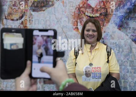 Tokio, Japan. 25 Nov, 2019. Eine Person nimmt ein Foto eines Philipino Freund neben einem Wandbild mit dem Bild von Papst Franziskus auf Anzeige an der Tokyo Dome, kurz vor dem Papst Franziskus Masse hat Tausenden von Menschen in Japan, die Masse ist eine der Aktivitäten von Papst Franziskus während seiner Reise durch einige asiatische Länder. Foto am 25. November 2019 berücksichtigt. Foto: Ramiro Agustin Vargas Tabares Credit: Ramiro Agustin Vargas Tabares/ZUMA Draht/Alamy leben Nachrichten Stockfoto