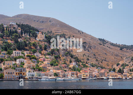 Blick auf die Küste der Insel Symi mit bunten Häuser im Sommer Tag, Griechenland, Europa Stockfoto