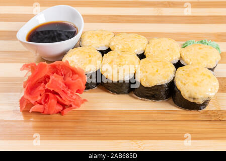 Gebackene Mohnblumen mit Käse in Gap. Auf der Planke. Auf einem roten Hintergrund. Stockfoto