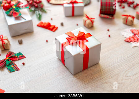 Geschenk am Tisch von Dekorationen und Geschenke umgeben. Konzept der Weihnachten Vorbereitung der Geschenke. Close-up. Stockfoto