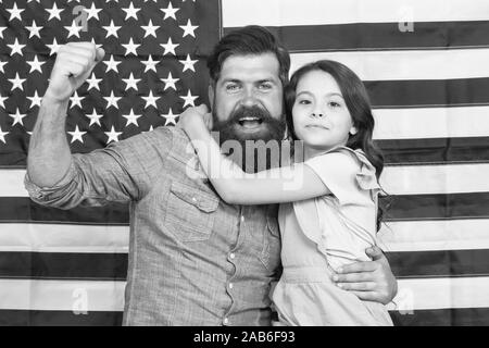 Ehrenkompanie der grosse Banner. Patriotische Familie feiern Flag Tag mit Banner Dekor. Vater und Tochter auf die amerikanische Fahne Hintergrund. Mann und einem kleinen Kind mit nationalen us banner Bärtigen. Stockfoto