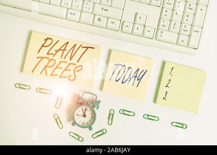 Handschrift text Bäume Pflanzen. Konzeptionelle foto Prozess der pflanzen einen Baum für Ackerbau und Forstwirtschaft Leer orange Quadrat Papiere und die Uhr von Th Stockfoto