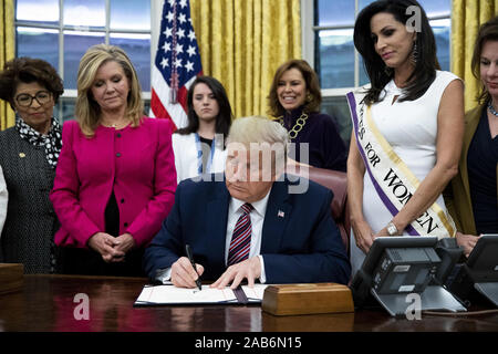 Washington, District of Columbia, USA. 25 Nov, 2019. US-Präsident Donald J. Trumpf (C) Zeichen "das Frauenwahlrecht Centennial Gedenkmünze Act', neben neben United States Senator Marsha Blackburn (Republikaner von Tennessee) (L), im Oval Office des Weißen Hauses in Washington, DC, USA, 25. November 2019. Trumpf 'H.R. 2423, das Frauenwahlrecht Centennial Gedenkmünze Act" - eine Rechnung, die Leitung der US Treasury, Minze und Ausgabe von bis zu 400.000 one-dollar Silber Münzen ehrt Frauen, die eine Rolle bei der Erlangung von Unterstützung für die 19. Änderung (Credit Bild: © gespielt Stockfoto