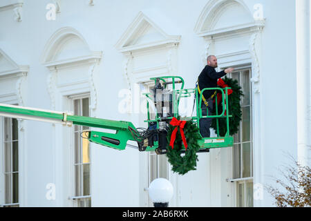 Washington, District of Columbia, USA. 25 Nov, 2019. Ein Arbeitnehmer hängt Weihnachten Kränze auf dem Weißen Haus in Washington, DC am Montag, 25. November 2019. Credit: Erin Scott/CNP/ZUMA Draht/Alamy leben Nachrichten Stockfoto
