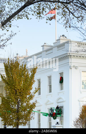 Washington, District of Columbia, USA. 25 Nov, 2019. Ein Arbeitnehmer hängt Weihnachten Kränze auf dem Weißen Haus in Washington, DC am Montag, 25. November 2019. Credit: Erin Scott/CNP/ZUMA Draht/Alamy leben Nachrichten Stockfoto