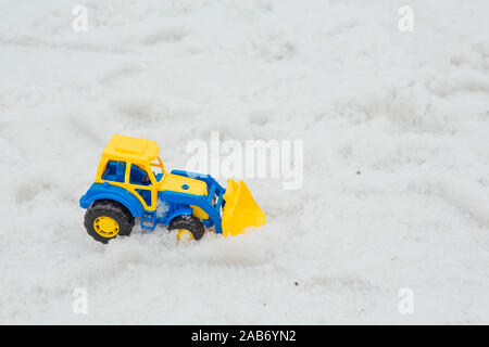 Spielzeug Lader auf einem nassen Schnee. Ein lustiges Spiel im Winter für Kinder. Stockfoto