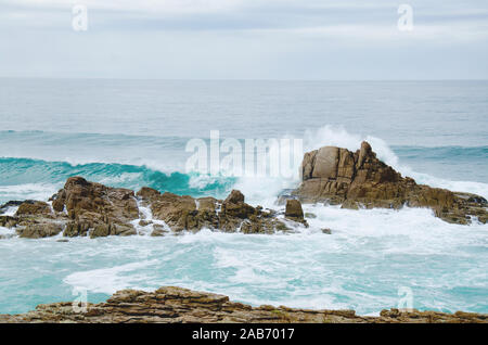 Buch mit leerem Einband, in das ein Text oder ein Design eingebettet werden kann, auf einem Holztisch mit negativem Platz auf der linken Seite Stockfoto