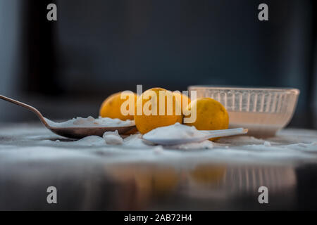Natron Maske in eine Glasschüssel auf Holz- Oberfläche zusammen mit etwas Natron gestreut auf der Oberfläche und Zitronen auf der Oberfläche. Zur blemi Stockfoto