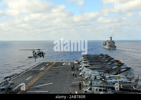 SOUTH CHINA SEA (8. Februar 2013) ein MH-60 s Sea Hawk-Hubschrauber zugewiesen, Hubschrauber Meer bekämpfen Squadron (HSC) 25 zieht aus dem Flugdeck amphibischer Angriff Schiff USS Bonhomme Richard (LHD-6) als das Schiff zu ziehen neben den Military Sealift Command Flotte Nachschub Öler USNS Rappahannock (T-AO 204) bereitet für einen laufenden Nachschub. Der Bonhomme Richard amphibische bereit-Fraktion derzeit zur Bereitstellung in den USA wird 7. Flotte Aufgabengebiet, am amphibischen Integration Training, Zertifizierung Übung teilnehmen und Teilnahme an der jährlichen multinationale kombiniert Stockfoto