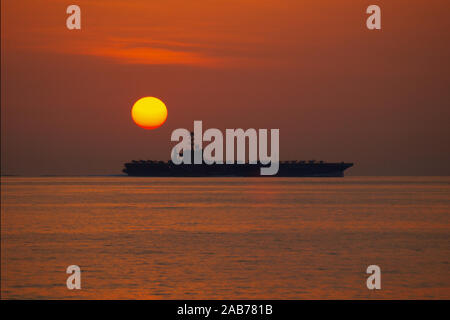 (Jan. 5, 2012) Der Nimitz-Klasse Flugzeugträger USS John C Stennis (CVN 74) betreibt im Arabischen Meer bei Sonnenuntergang. John C Stennis ist in die USA 5 Flotte Verantwortungsbereich Durchführung Maritime Security Operations eingesetzt, Theater Sicherheit Bemühungen um Zusammenarbeit und Unterstützung für die Operation Enduring Freedom. Stockfoto