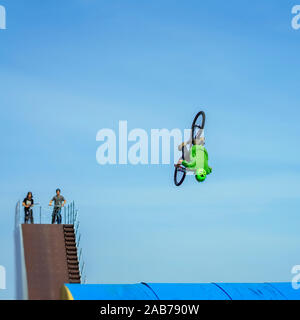 Antenne BMX Stunt. Junge unkenntlich Fahrradfahrerin performing air Trick zurück. Extreme Sport, Jugend Kultur und Freizeit Stockfoto