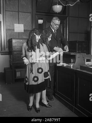 Die Fingerabdrücke abgenommen. Fred Sandberg, Bezirk Polizei Fingerabdruck Experte, erzählt Daisy und Violet Hilton, der iamese Twins, "abgesehen von ihrer Fingerabdrücke. Oktober 6, 1926 Stockfoto