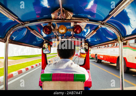 Okt 24, 2019 Bangkok, Thailand - Bangkok Tuk Tuk taxi Reiten auf belebten Straße Ansicht von hinten Fahrer mit bunten Sitz und Dach Stockfoto