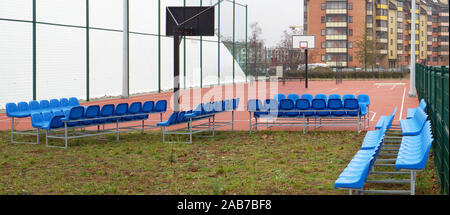 Kunststoff blau Bänke auf Metallrahmen in der Nähe des neuen, modernen Basketball Stadion in kleinen europäischen Stadt Stockfoto