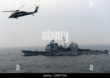 (Jan. 29, 2013) Eine MH-60S Sea Hawk Hubschrauber vom Eightballers der Hubschrauber Meer Combat Squadron (HSC) 8 fliegt durch die ticonderoga-Klasse geführte-missile Cruiser USS Mobile Bay (CG53) während einer Auffüllung-auf-See. Mobile Bay, auf die John C Stennis Carrier Strike Group zugewiesen wurde, werden in den USA 5 Flotte Verantwortungsbereich Durchführung Maritime Security Operations eingesetzt, Theater Sicherheit Bemühungen um Zusammenarbeit und Unterstützung für die Operation Enduring Freedom. Stockfoto