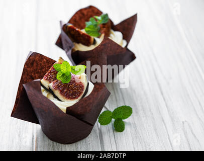 Cupcakes mit Feigen auf einem weißen Holz- Hintergrund Stockfoto