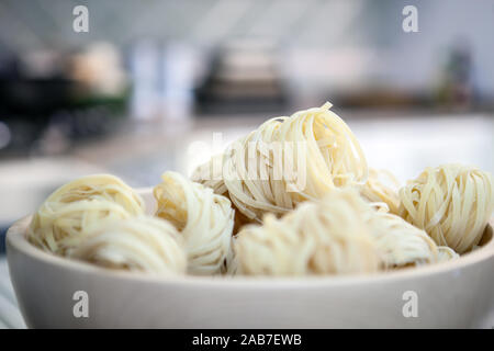 Sechs ungekocht Rollen des Italienischen tagliatelle Nudeln Pasta oder auf einem weißen Teller bereit für den Einsatz im mediterranen Stil kochen Stockfoto