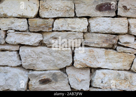 Kalkstein Mauerwerk, Rauhe ungleiche Stücke aus Sandstein von verschiedener Größe, Textur Hintergrund Hintergrund. Weiß Grau texturierte Oberfläche Stockfoto