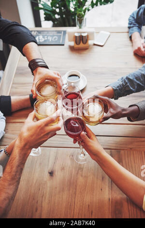 Die Aussicht von oben. Hände von Menschen mit Gläser Whisky oder Wein, Feiern und Toasten zu Ehren der Hochzeit oder andere Feier Stockfoto