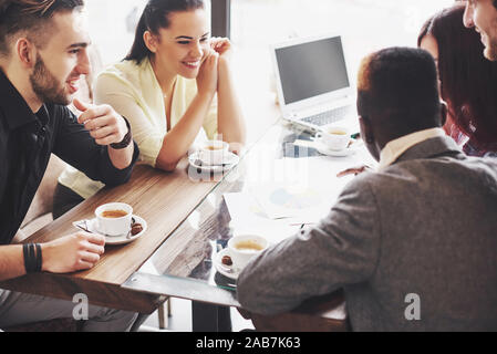 Gruppe von Unternehmern, die Arbeiten mit einem Laptop und halten ein Dokument Stockfoto