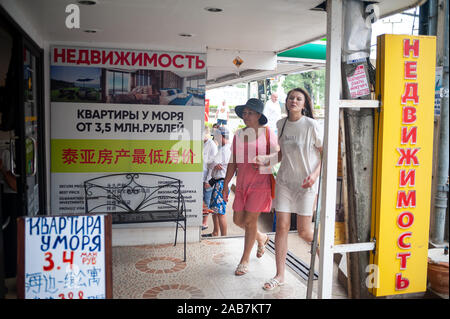 15.11.2019, Phuket, Thailand, Asien - Urlauber vor einer Geschäftsstelle mit Zeichen in kyrillischer Schrift in Karon Beach. Stockfoto